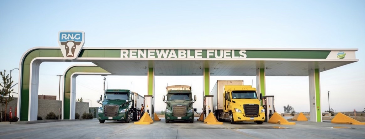 RNG station with cow on logo and trucks fueling