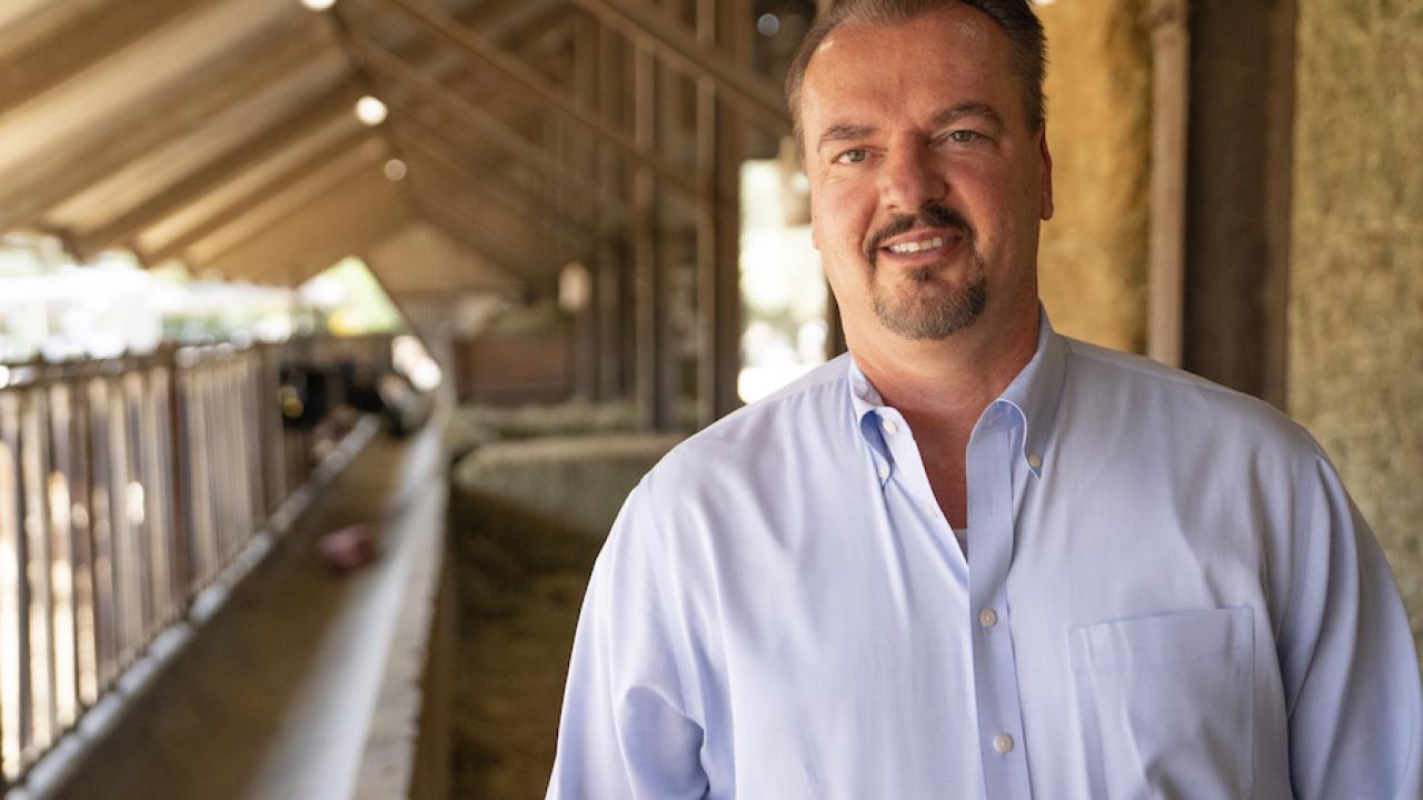 Frank Mitloehner standing in front of feedlot in blue shirt