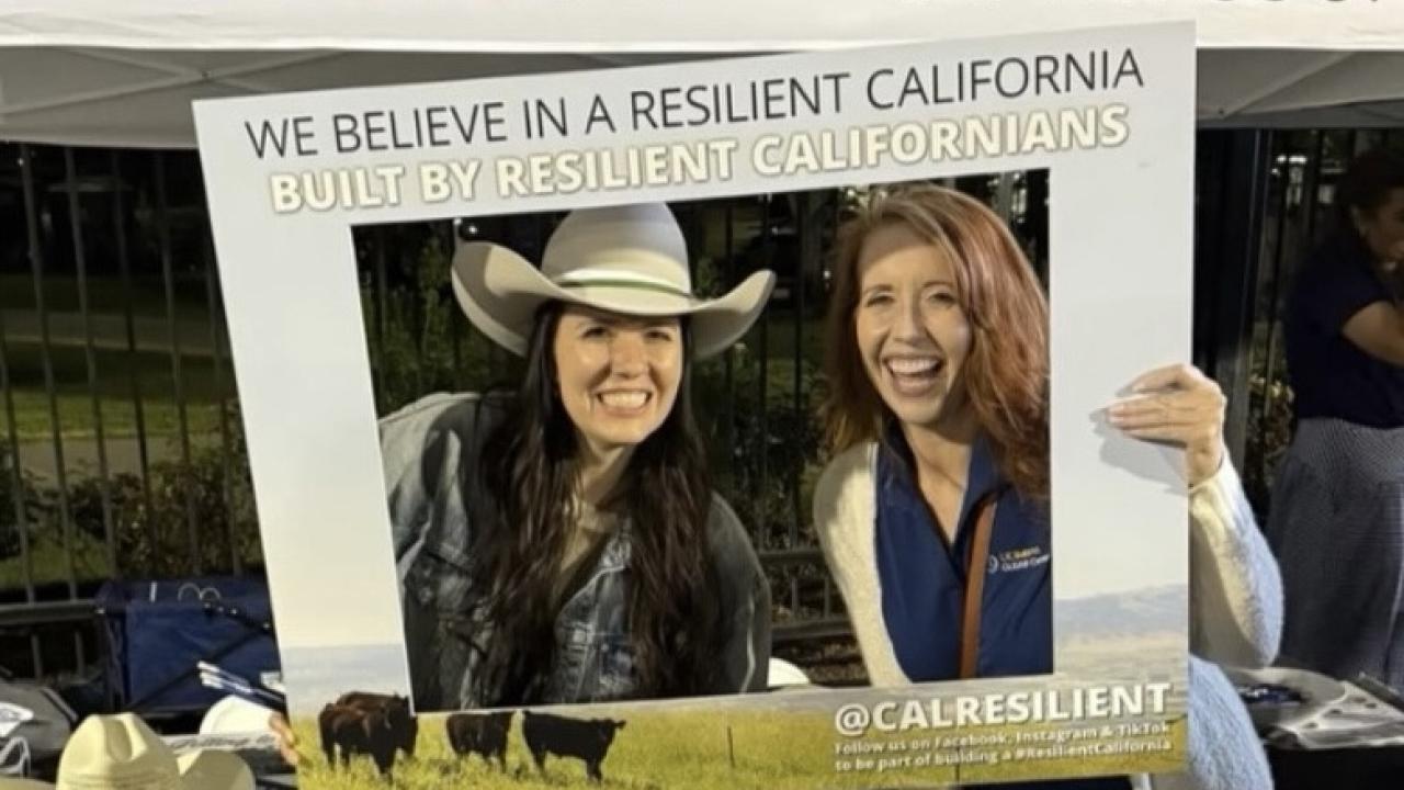 Katie Roberti and Tracy Sellers stand in a picture frame at the Salute to Ag Game