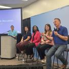 A group of panelists sit next to one another on stage during a panel discussion at the World Pork Expo