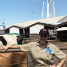 woman with baseball cap standing in front of UC Davis dairy cow pens